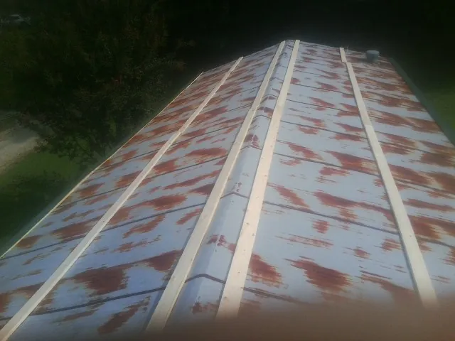 Rusted metal roof panels with new wood purlins before replacement — Storm Damage Roof Repair in Saint Bonifacius by Roofing Brothers