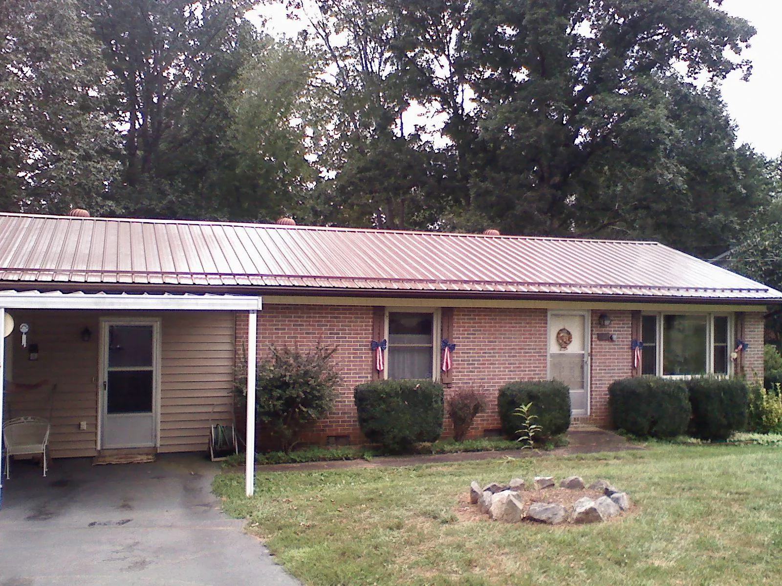 Bronze metal roof and carport on a brick ranch home — Roof Repair work by our crew in Saint Bonifacius